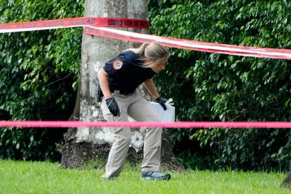 A law enforcement official works outside of Trump International Golf Club Monday